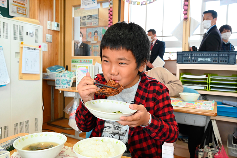 「幸せ上々（あげあげ）竜田揚げ」を食べる児童