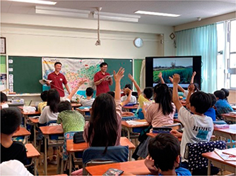 授業で元気よく手を挙げる子供たち
