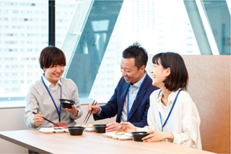 社食で昼食を食べる社員3人