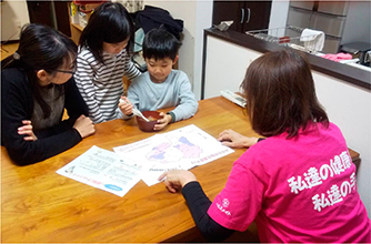 家庭訪問で味噌汁の塩分測定をする様子