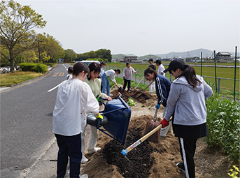 学内で土づくりする学生たち
