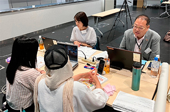 2人学生と意見交換する2人の企業担当者