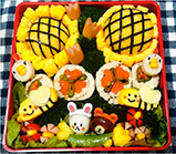 いろいろなごはんやおかずで花があしらわれた弁当