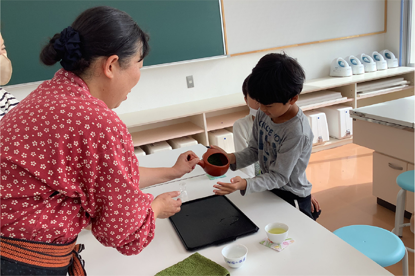 お茶のいれ方を教わっている子供