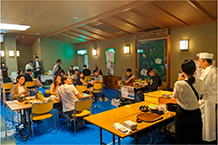 料理人からおにぎりの作り方について教わる様子