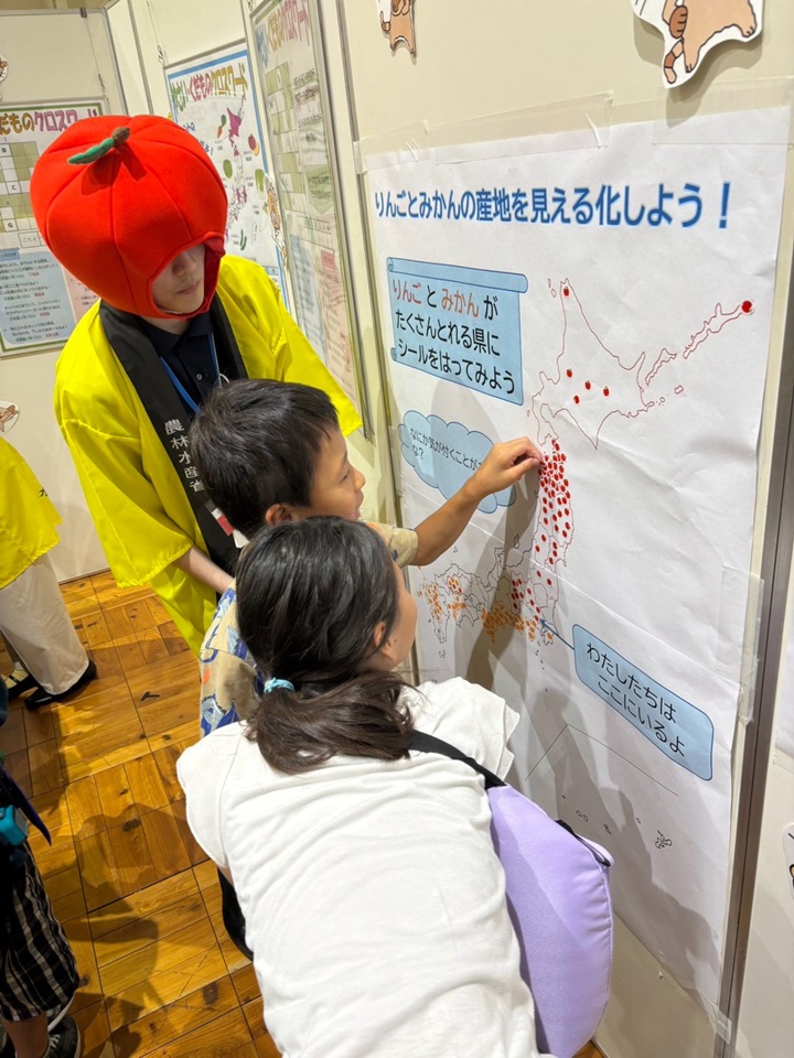 日本地図にシールを貼るこども