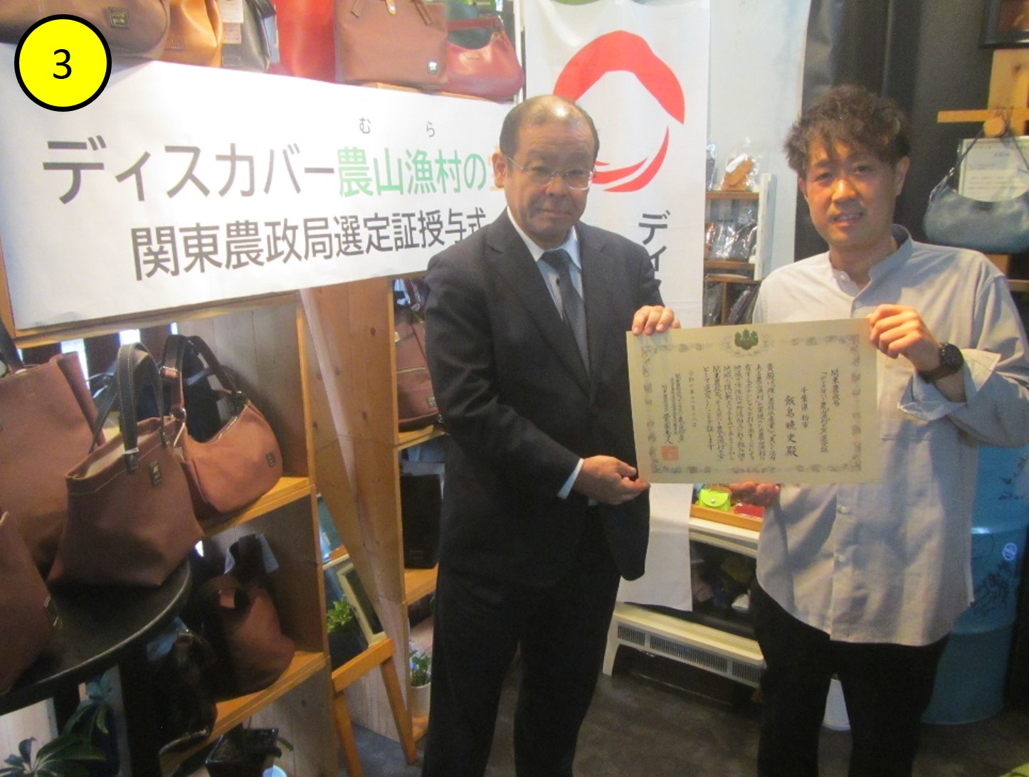 飯島様が経営する柏レザーファクトリーショップ「Harito」店内にて。阿部地方参事官と飯島様。