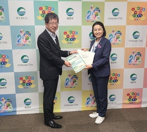 （左）竹山地方参事官を（右）筑西市長に情報提供資料を手渡しているところ