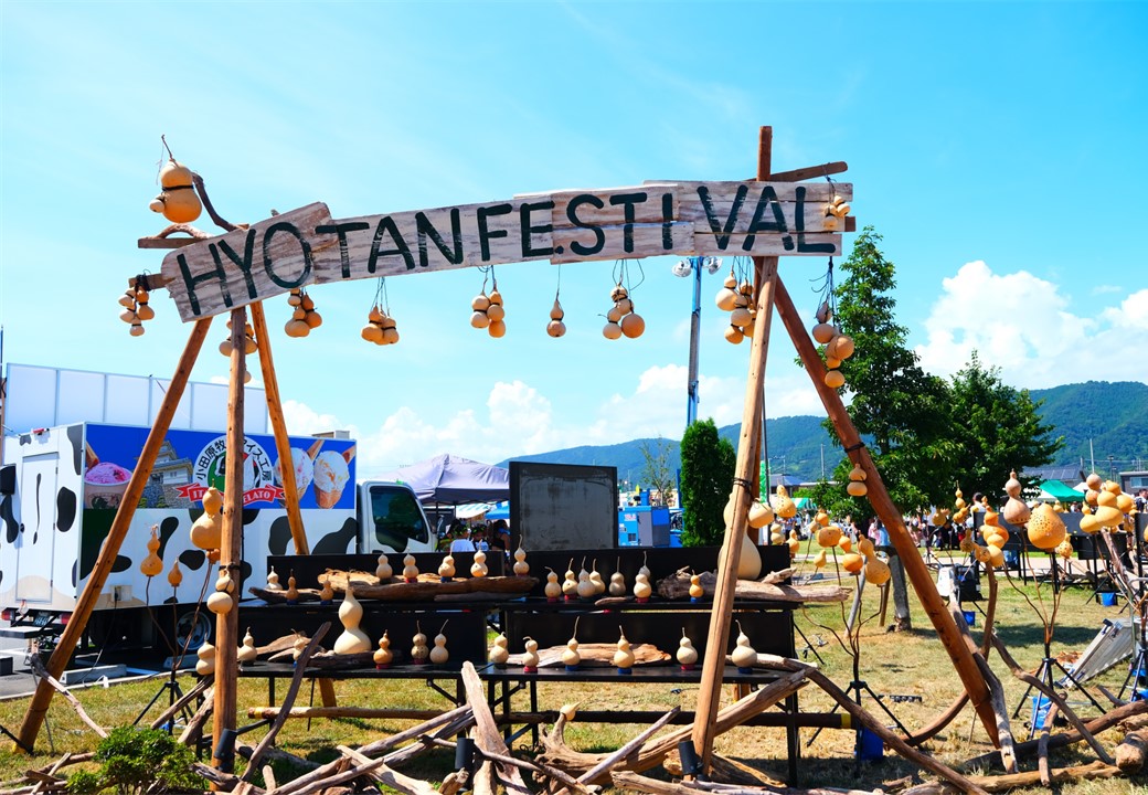 HYOTAN　FESTIVALの看板にひょうたんが吊るされている写真