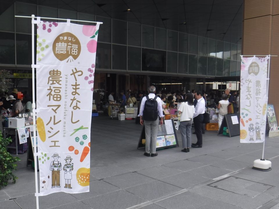 「やまなし農福マルシェ」ののぼり旗と会場の様子