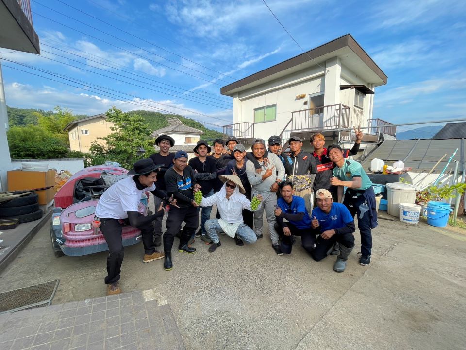 傘帽子をかぶった水野トムさんと仲間たち