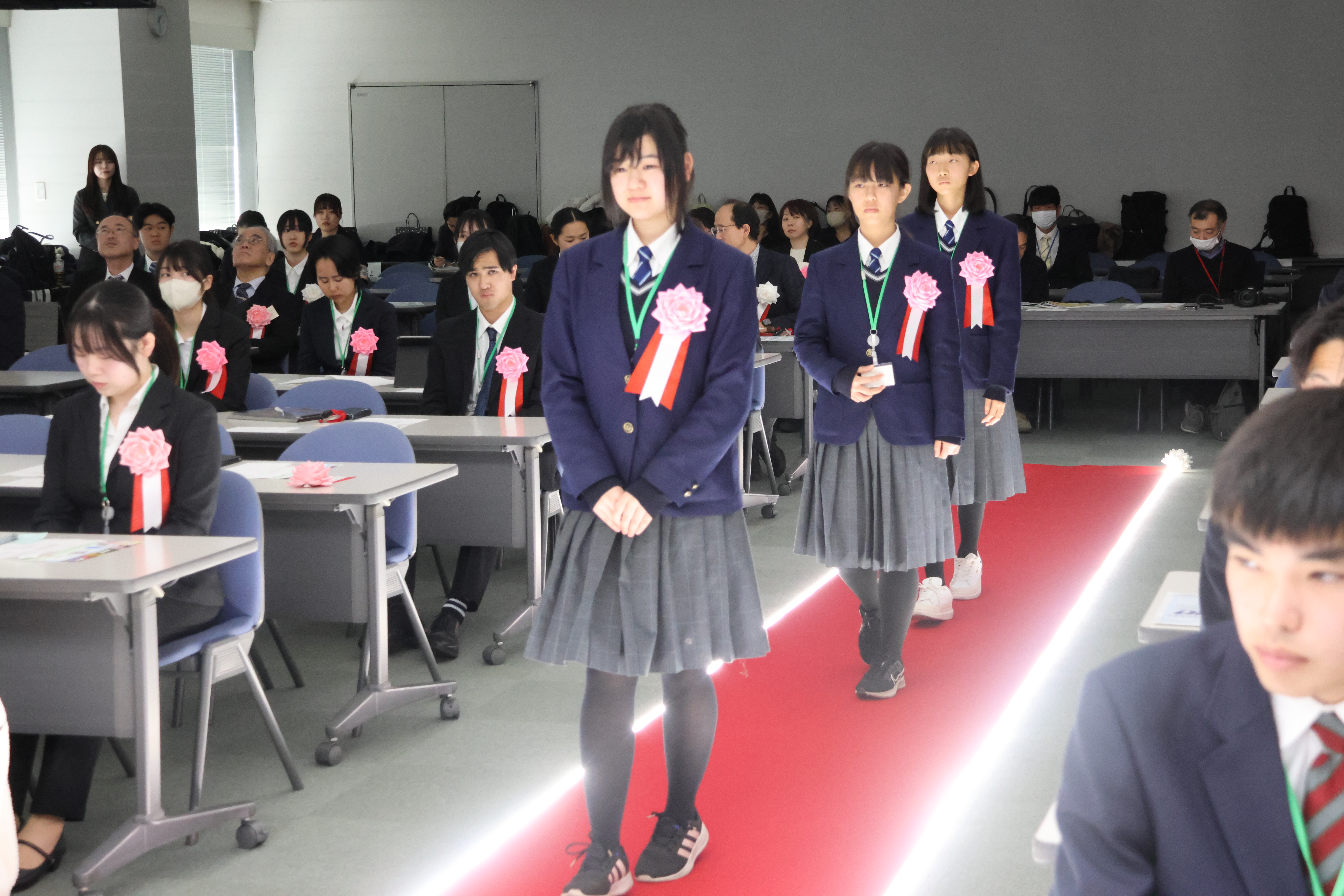 レッドカーペットを歩く学生