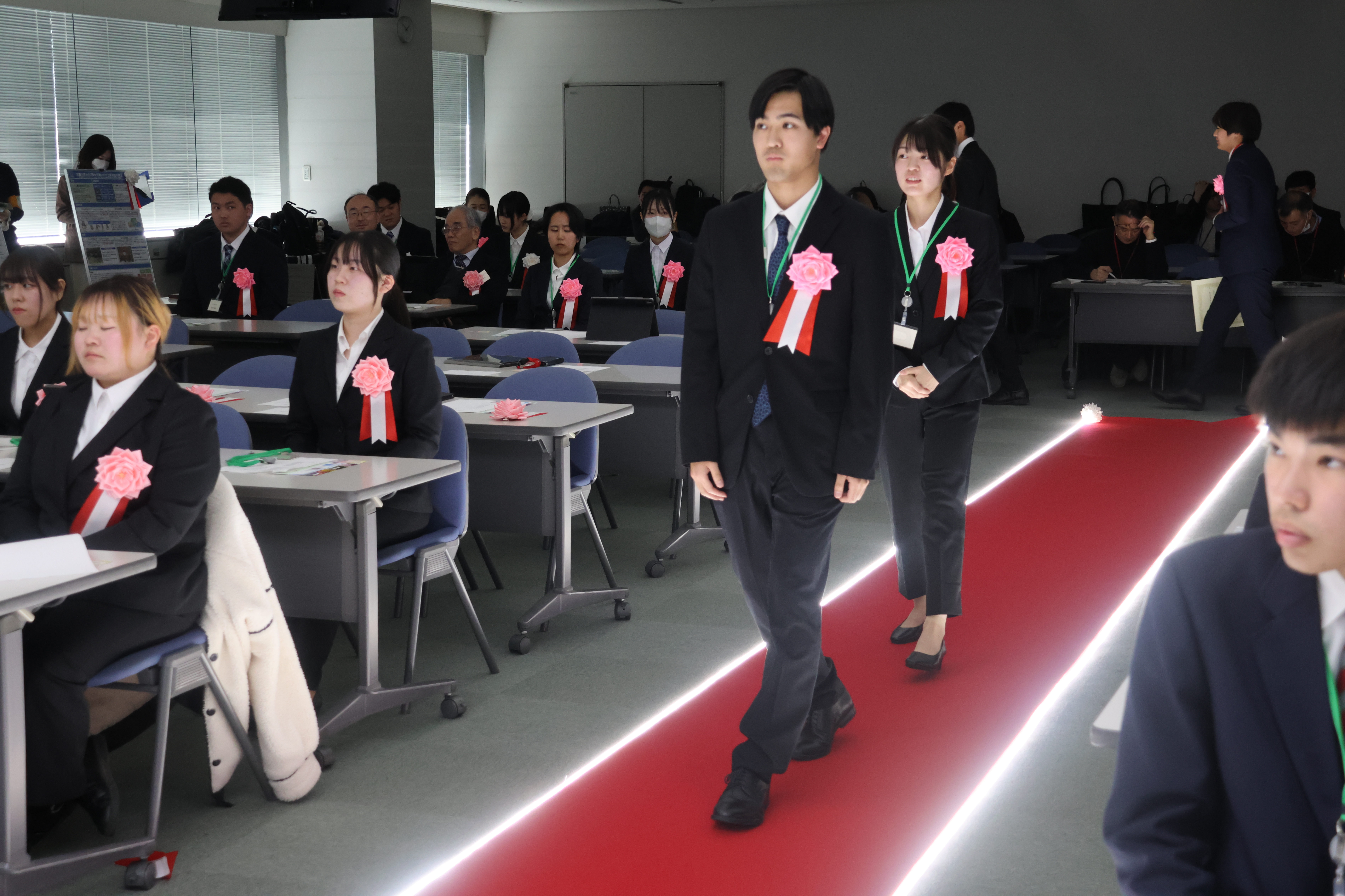 レッドカーペットを歩く学生