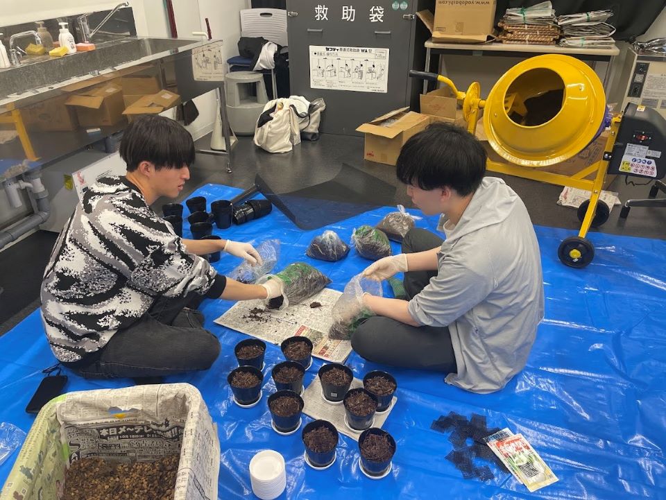 学生がポットに土を詰める様子