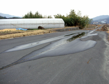 地中に埋まる前河原伏せ越しからの漏水で、地上のアスファルトに水がしみ出しています。