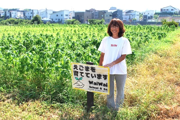 えごま畑の前で生産者女性の笑顔の様子
