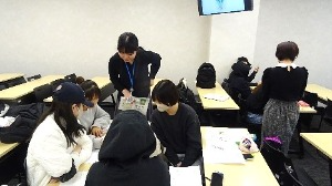 学生が書いたメモを見ながらアドバイスする職員