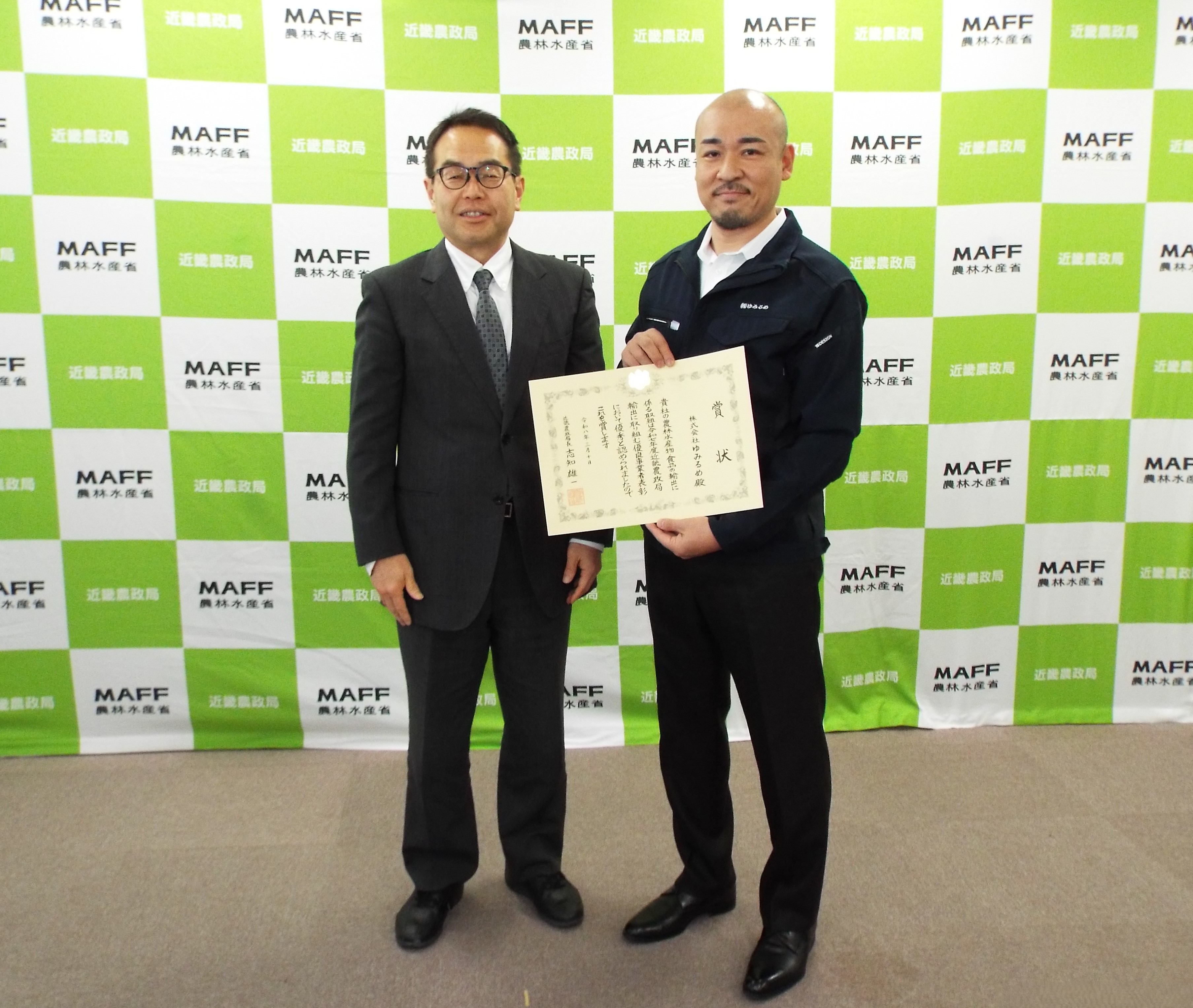 志知局長(左側)と向山眞一郎代表取締役