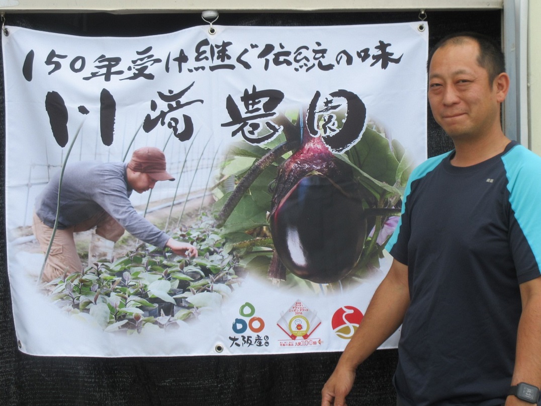 直営店の前に立つ川崎さん