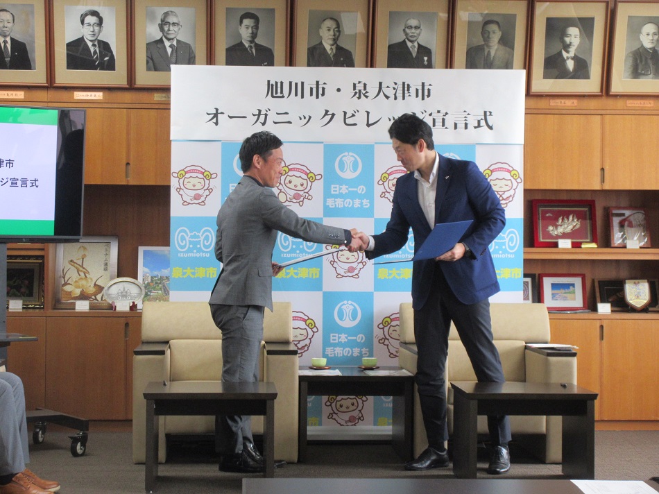 がっちり握手する両市長
