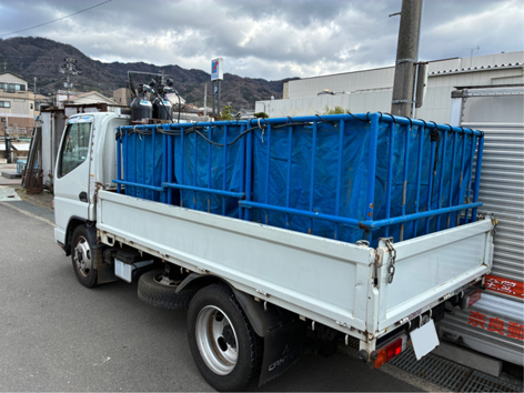 白いトラックに積まれた青い水槽