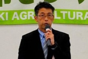 マイクを手に挨拶する参事官