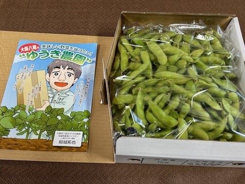 箱づめされた枝豆とゆうきさんの似顔絵パンフレット