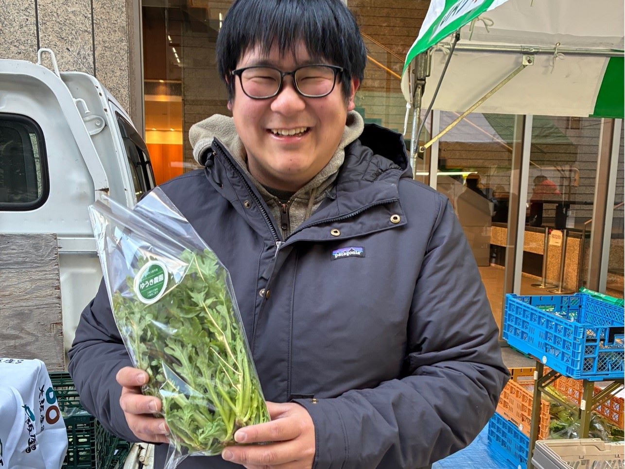 商品の八尾えだまめを手ににこやかなゆうきさん