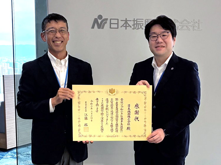 感謝状とともに記念撮影する有江地方参事官と伊達代表取締役社長