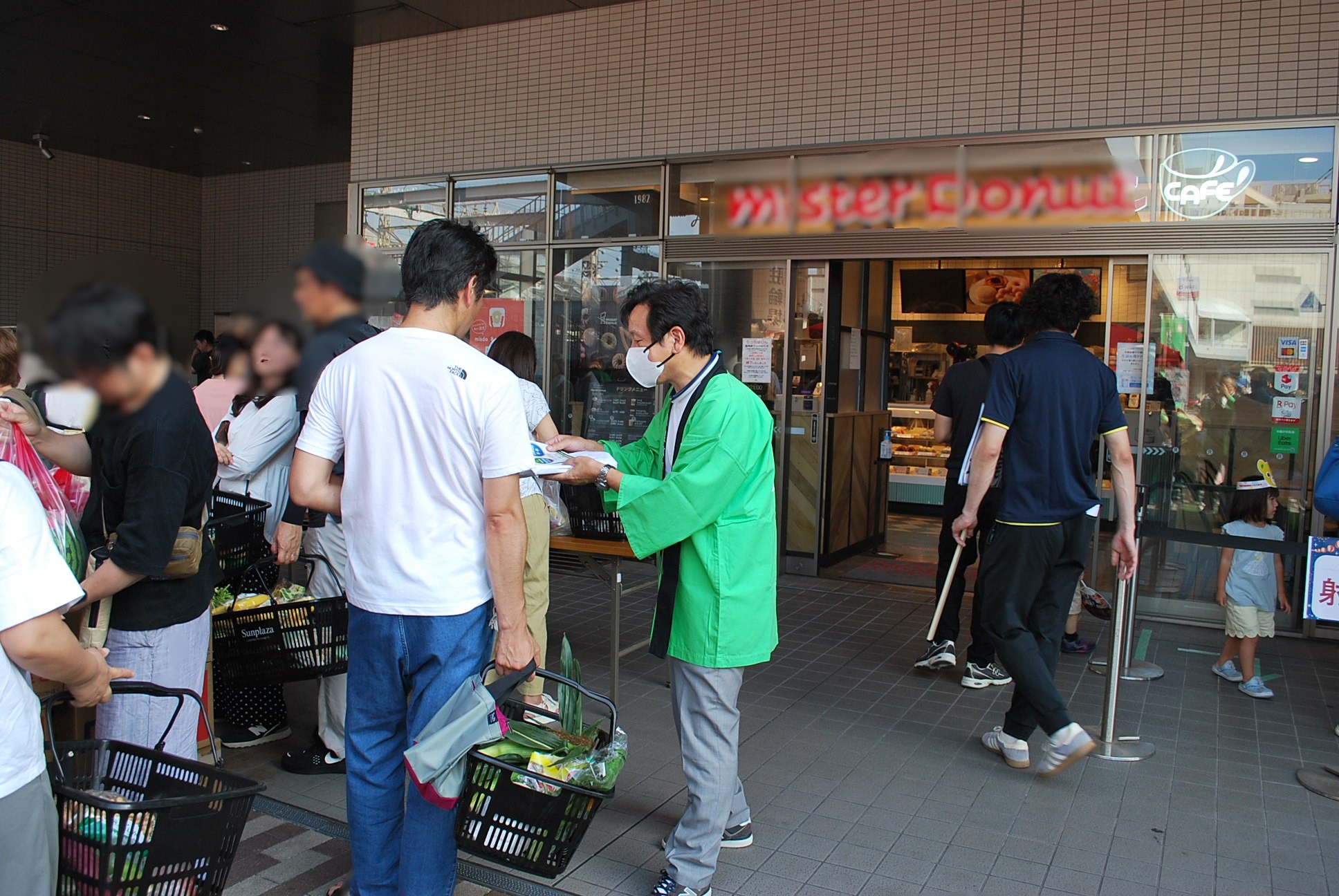 買い物客へ説明しながらチラシを配付する男性職員