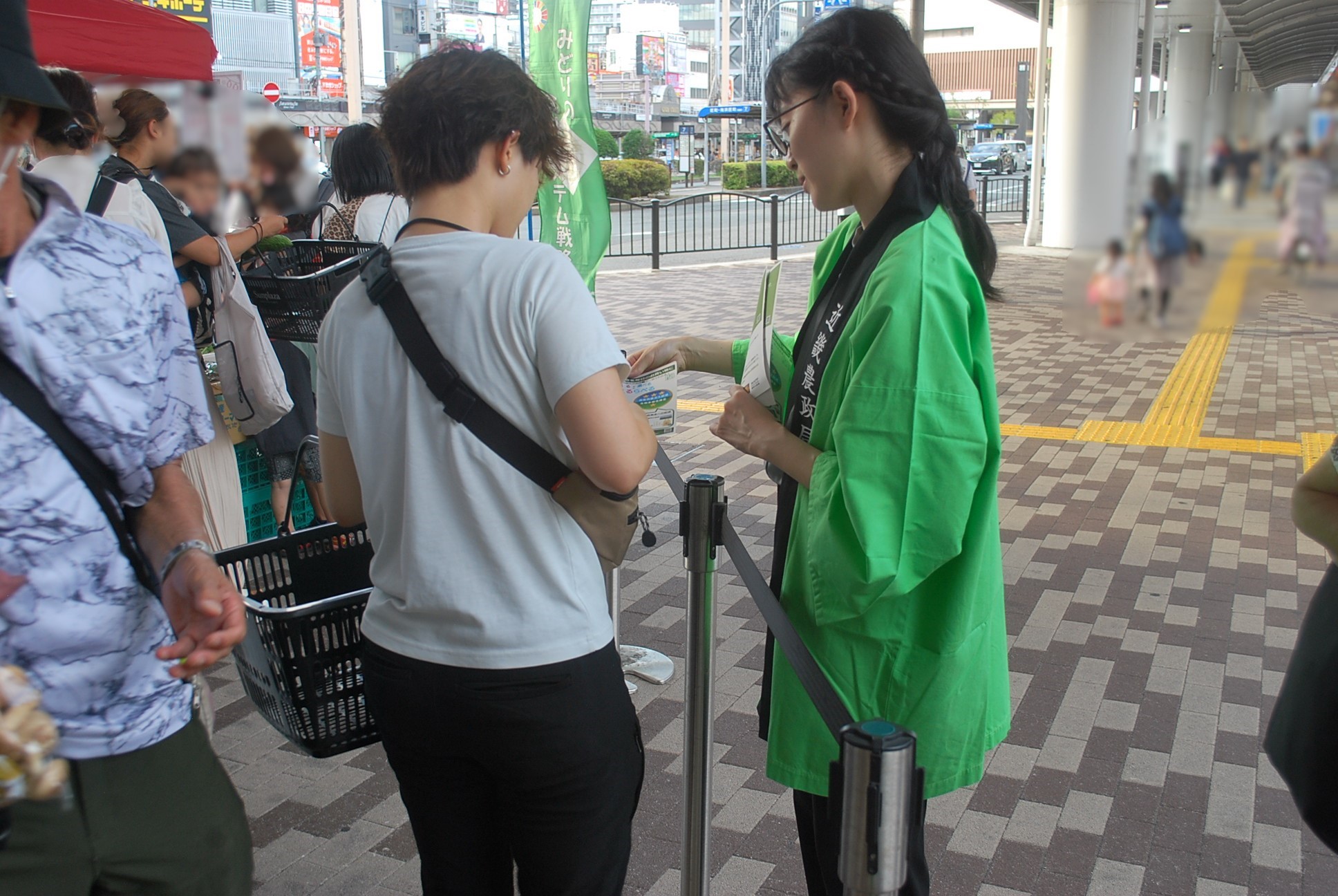 買い物客へ説明しながらチラシを配付する女性職員