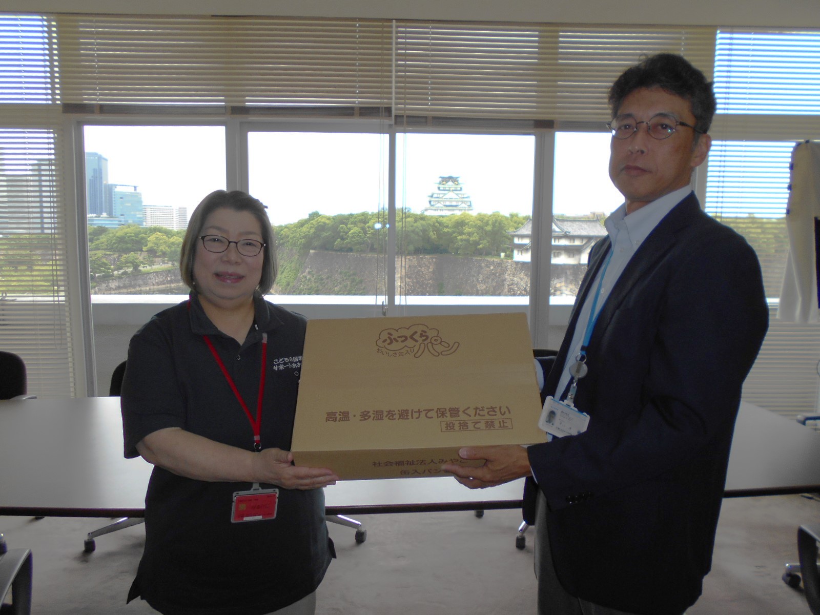 有江参事官(右)からフードバンクへの引渡し