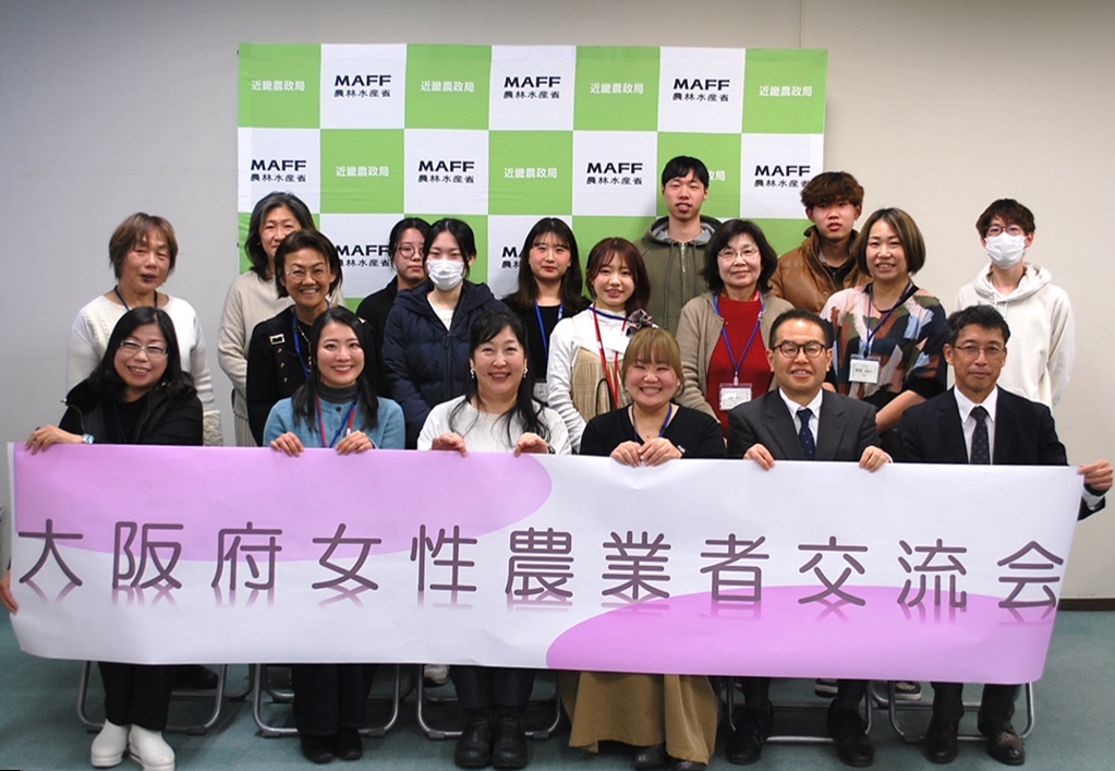 横断幕を手に記念撮影