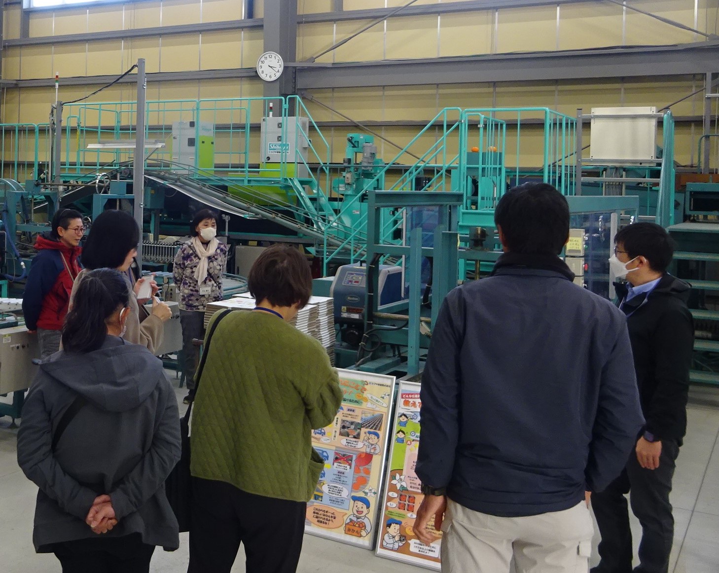 農業教育実習棟においてAI選果機について説明を受ける参加者