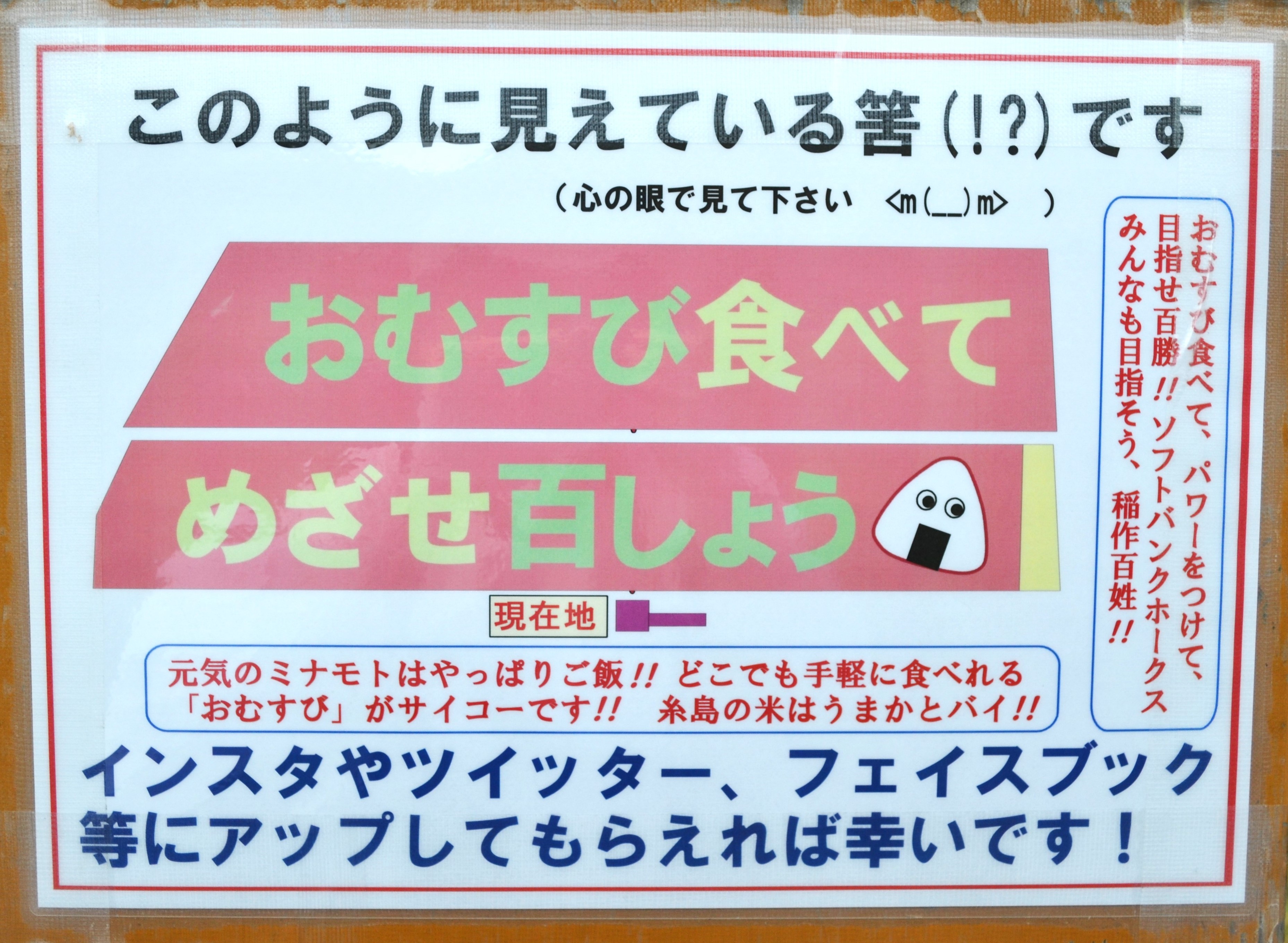 田んぼアートを紹介する看板、このように見えている筈です「おむすび食べてめざせ百しょう」