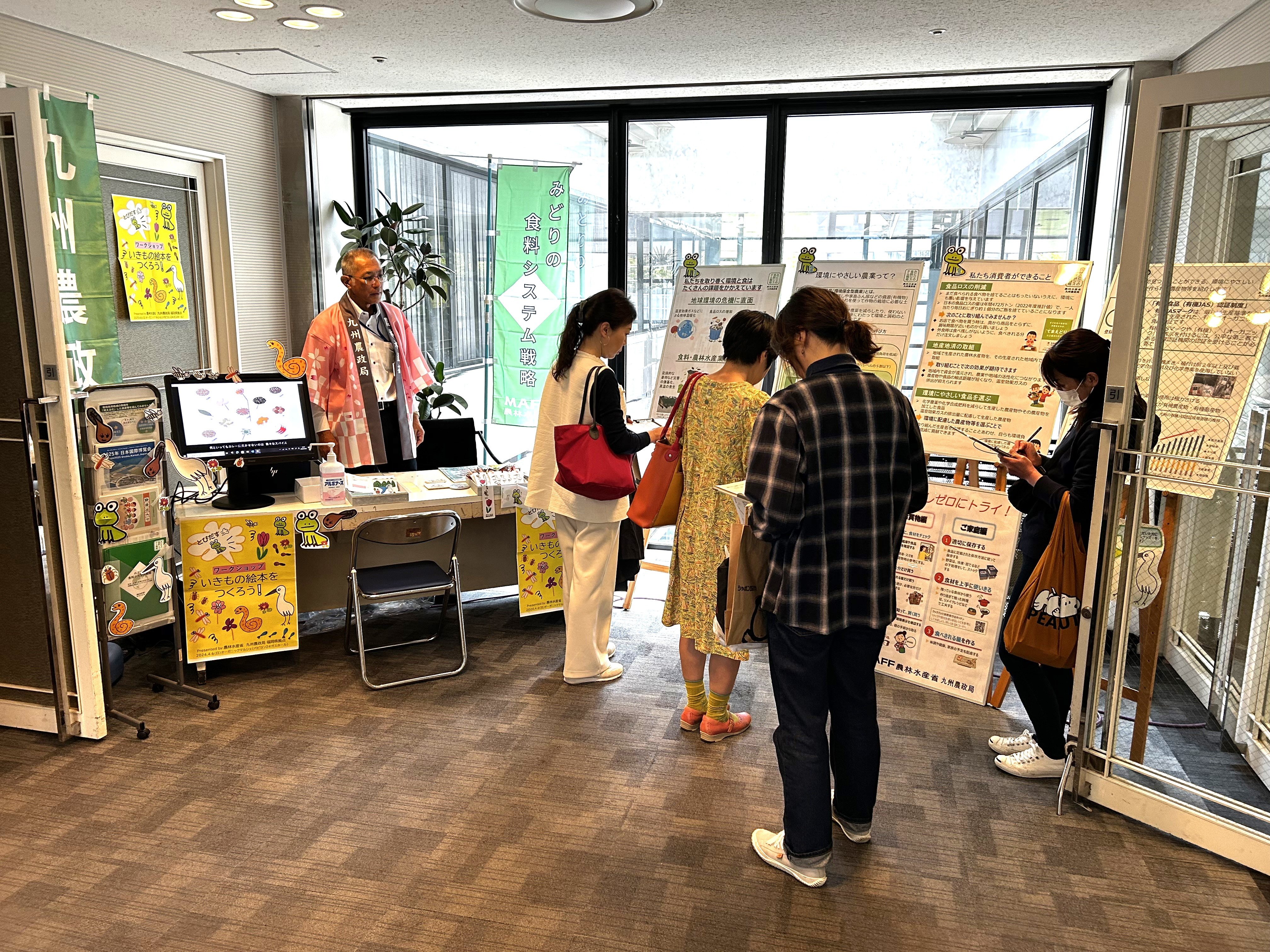 出展ブースに立ち寄りパネルなどの展示品を見ている来場者