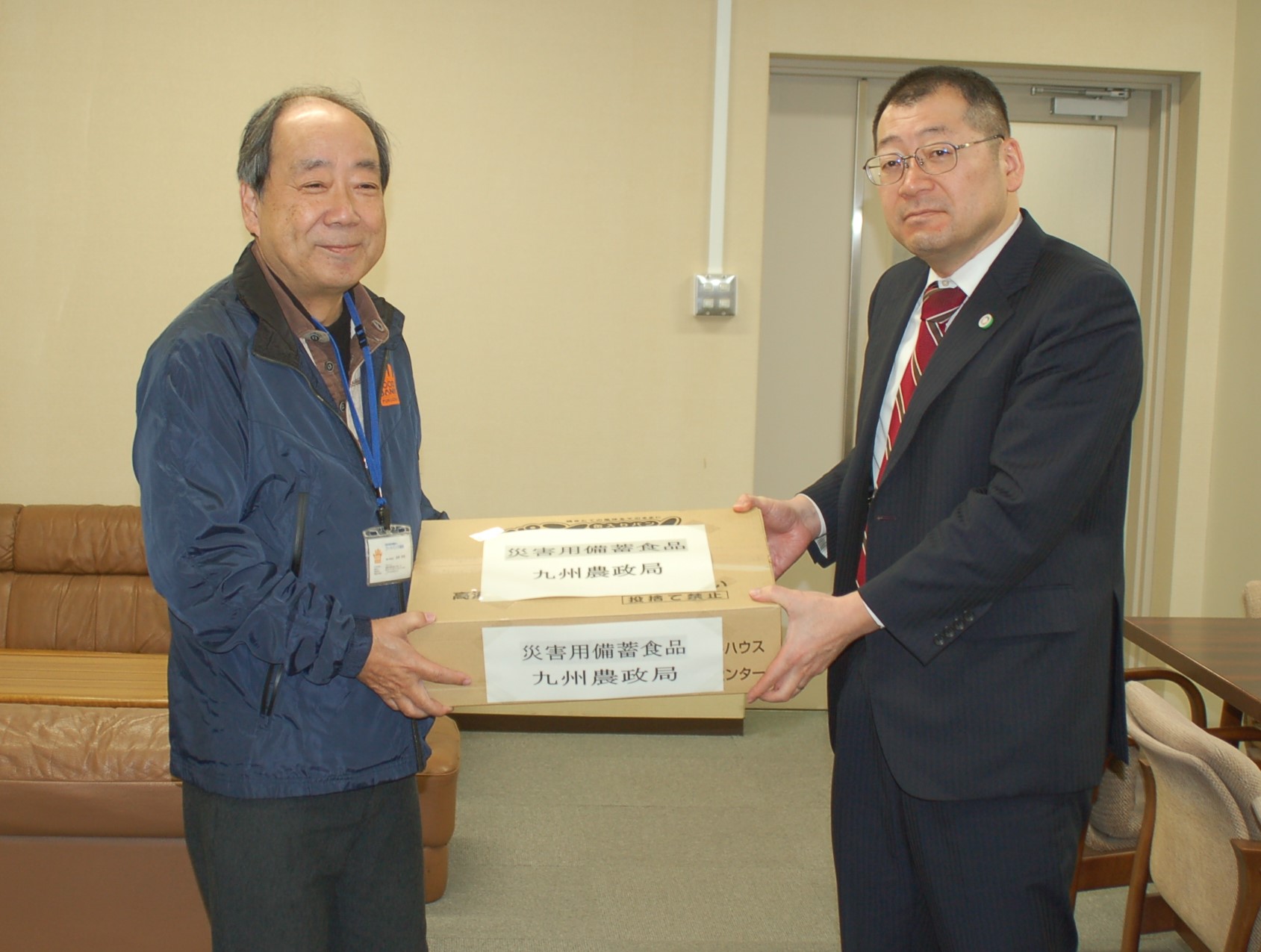 フードバンク福岡事務局長へ提供食料品を手渡している福岡県拠点小林地方参事官