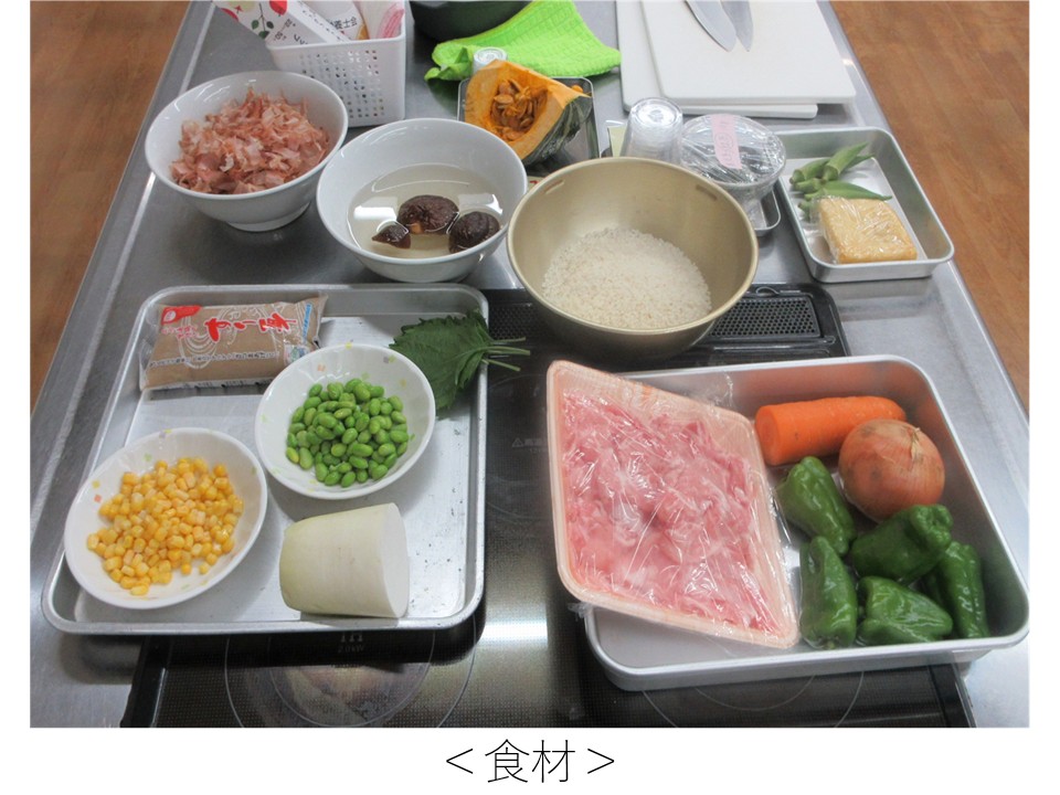 調理台の上に並べられた料理の食材一式。米、肉、野菜、豆類など複数の食材がトレーに整理されている