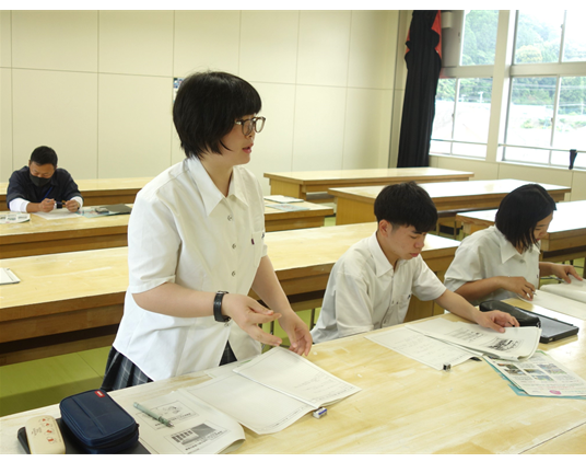 資料を手元に起立して発言する生徒