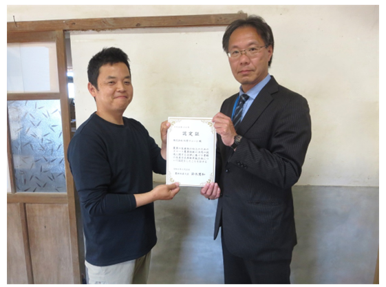 認定証を手に記念撮影する松原ファーム代表取締役と山下地方参事官