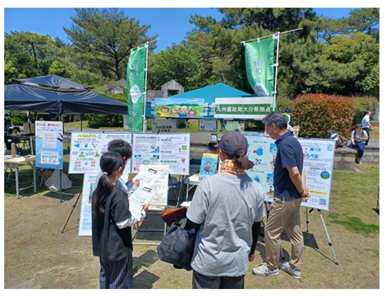 県拠点ブースの前のパネルを見る来場者