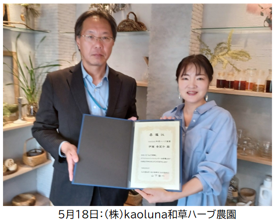 委嘱状を手にする山下地方参事官とKaoluna和草ハーブ農園