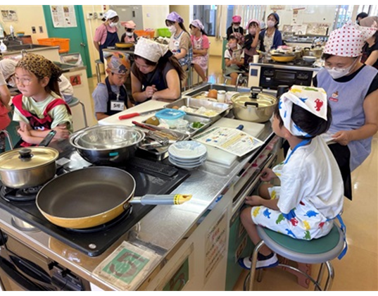 県拠点職員の説明を聞く親子料理教室参加者