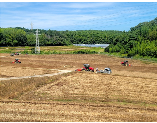広がる農地で、複数の農業機械が作業を行っています。