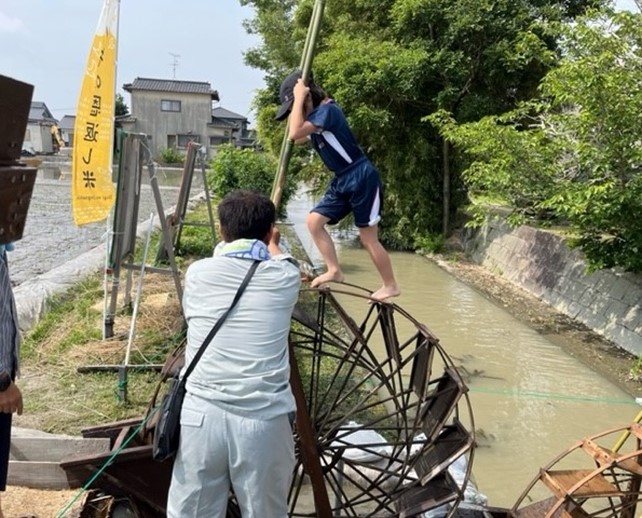 足踏み水車に乗る少年