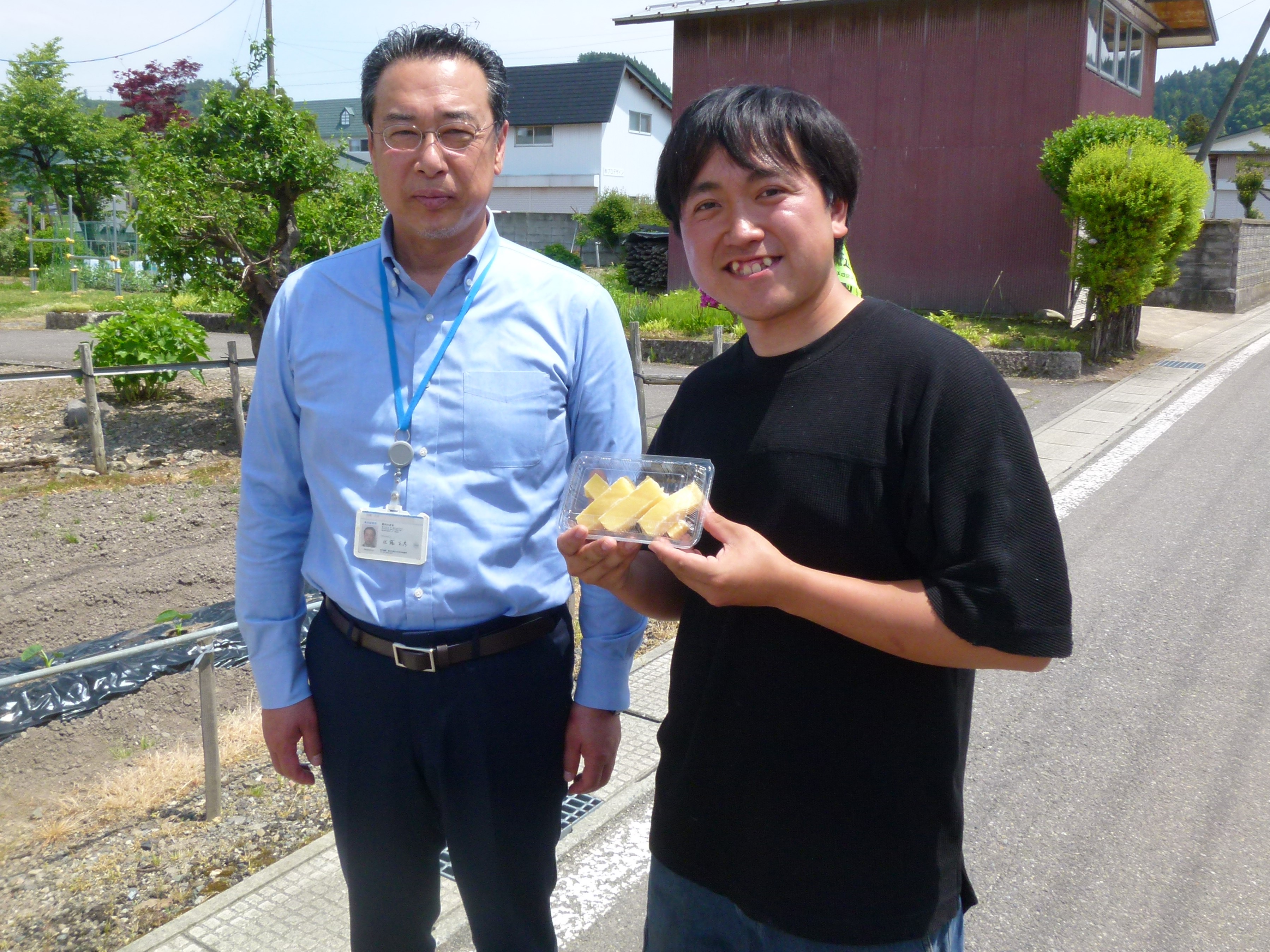 右 株式会社 翠久の里 上野氏 左 秋田県拠点 佐藤参事官 出来立てのバター餅 大仙市で農業用ドローンを活用した水稲湛水直播の実演会が開