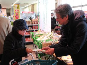 リーフレットを買い物客に手渡す岩手県拠点職員