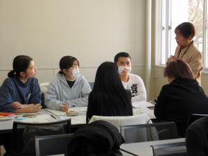 販売業者の小野節子さん（右上）からアドバイスを受ける学生たち