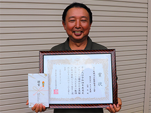 賞状を手にする 牧野聡代表取締役