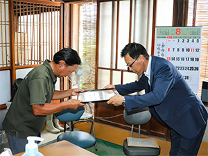 佐々木地方参事官（右）から 牧野代表（左）へ賞状を授与